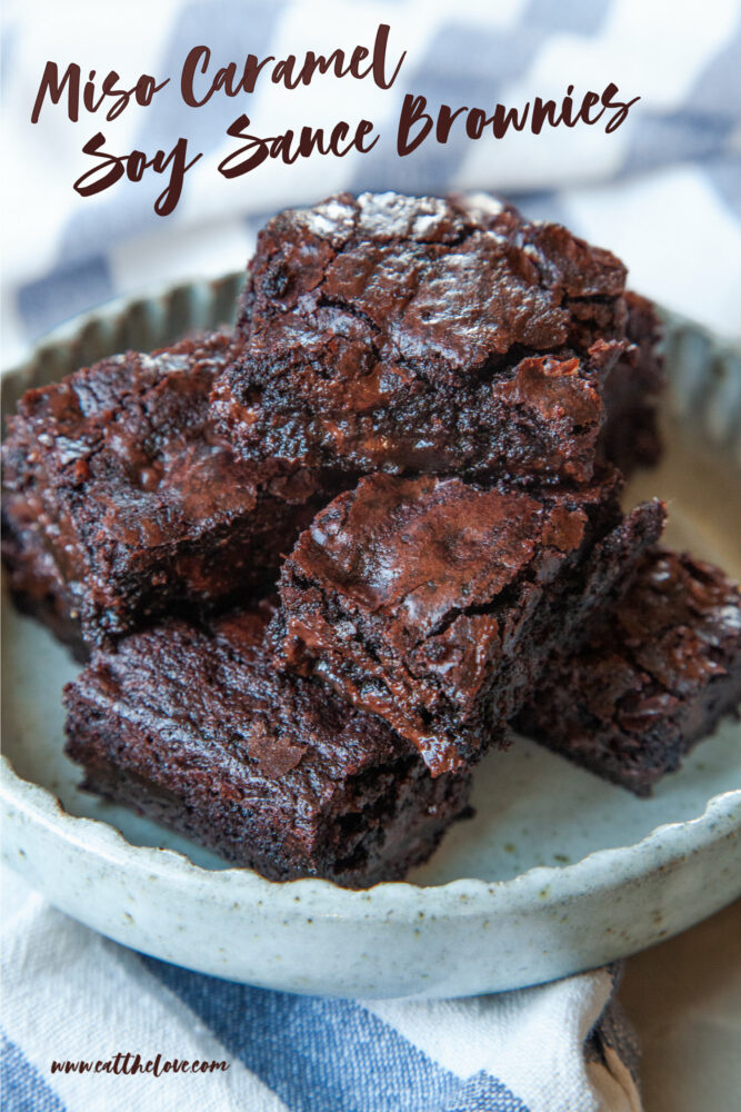 A small plate of miso caramel soy sauce brownies. The plate is sitting on a blue and white striped napkin.