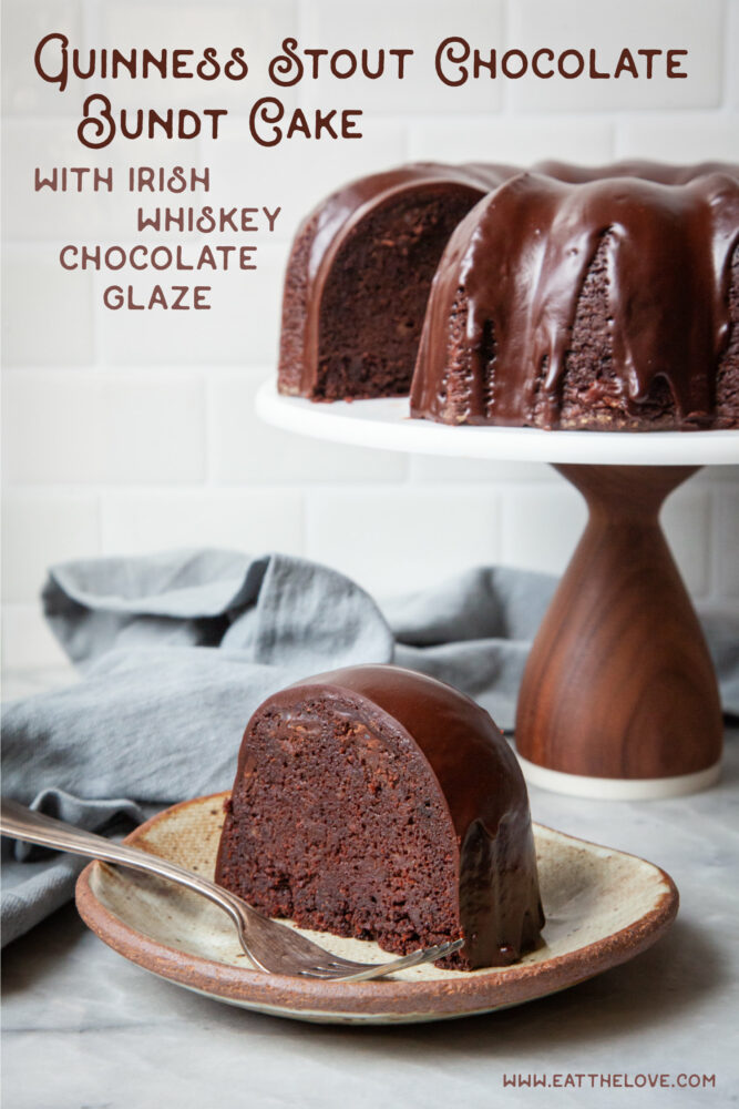 A slice of Guinness chocolate bundt cake on a plate, with the remaining cake in the background. There is a blue cloth napkin next to the plate.