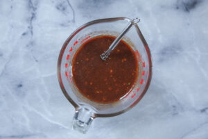 A glass measuring cup with the miso-glaze mixed in it.