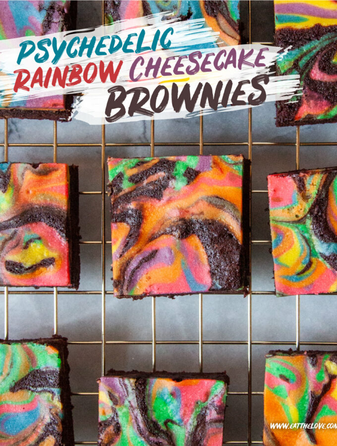 Rainbow cheesecake brownies sitting on a wire cooling rack.