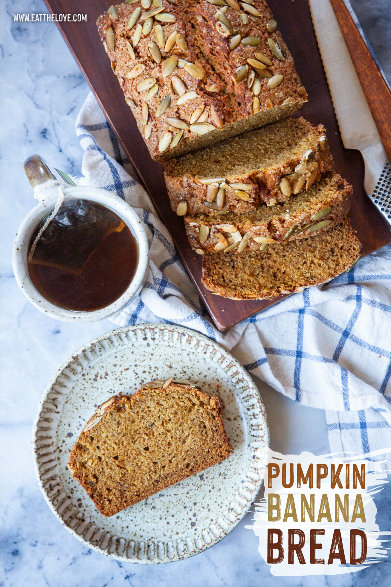 A slice of pumpkin banana bread on a plate, with a mug of tea and the remaining pumpkin banana bread sliced on a cutting board next to the plate.