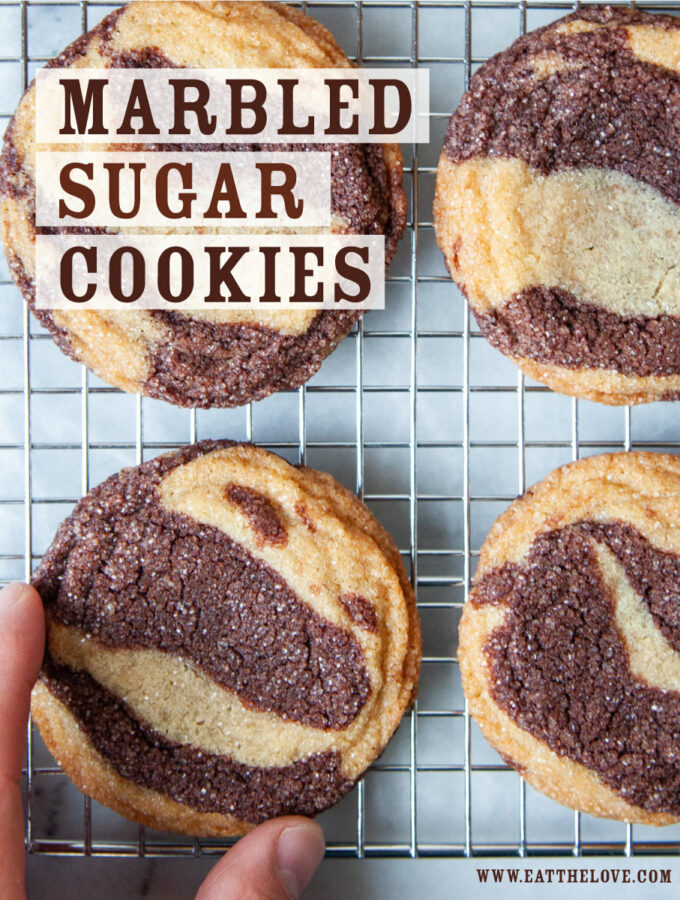 A wire cooling rack of marbled sugar cookies with a hand reaching for one cookie. The text on the image says "Marbled Sugar Cookies".