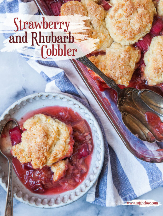 A bowl with a serving of strawberry rhubarb cobbler in it, and the remaining cobbler in a glass casserole dish next to the bowl.