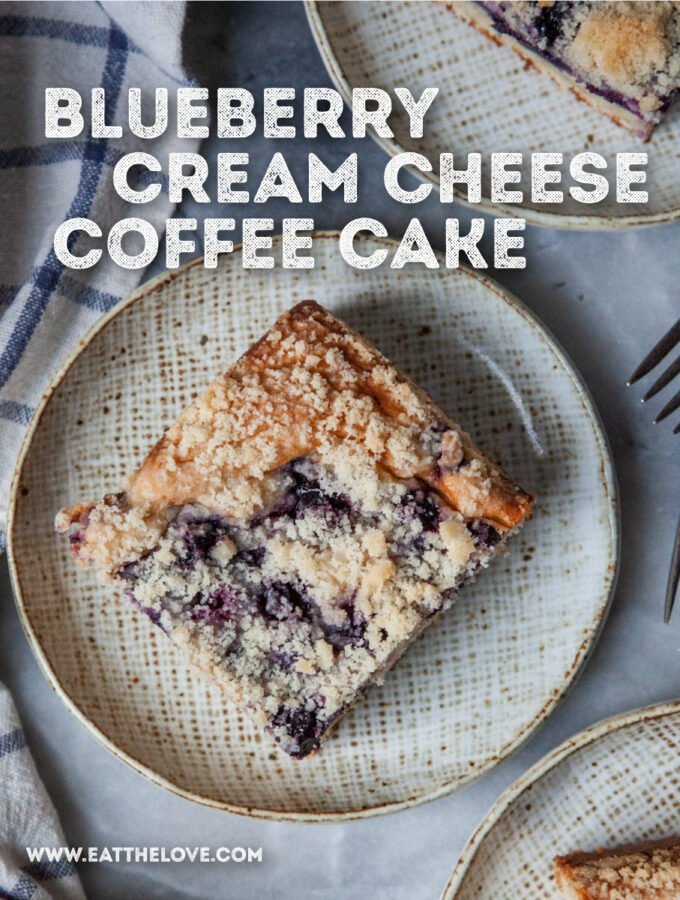 Pieces of blueberry cream cheese coffee cake on a ceramic plates. There is a blue checkered cloth napkin next to the plates. The text on the image says "Blueberry Cream Cheese Coffee Cake".