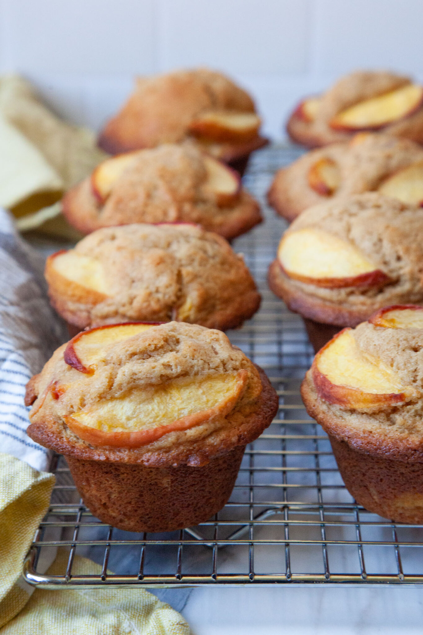 Ginger peach muffins on a wire cooling rack.