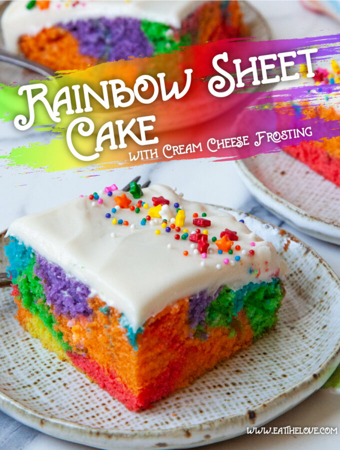 A slice of rainbow sheet cake with cream cheese frosting on a plate. Behind the plate is more pieces of cake.