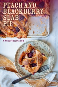 A square slice of peach and blackberry slab pie on a plate, with the remaining pie next to it. The text says Peach and Blackberry Slab Pie.