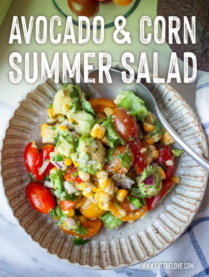 A bowl of avocado and corn salad, with an ear of corn, grape tomatoes, and a lime next to the bowl. The type on the image says Avocado and Corn Summer Salad.