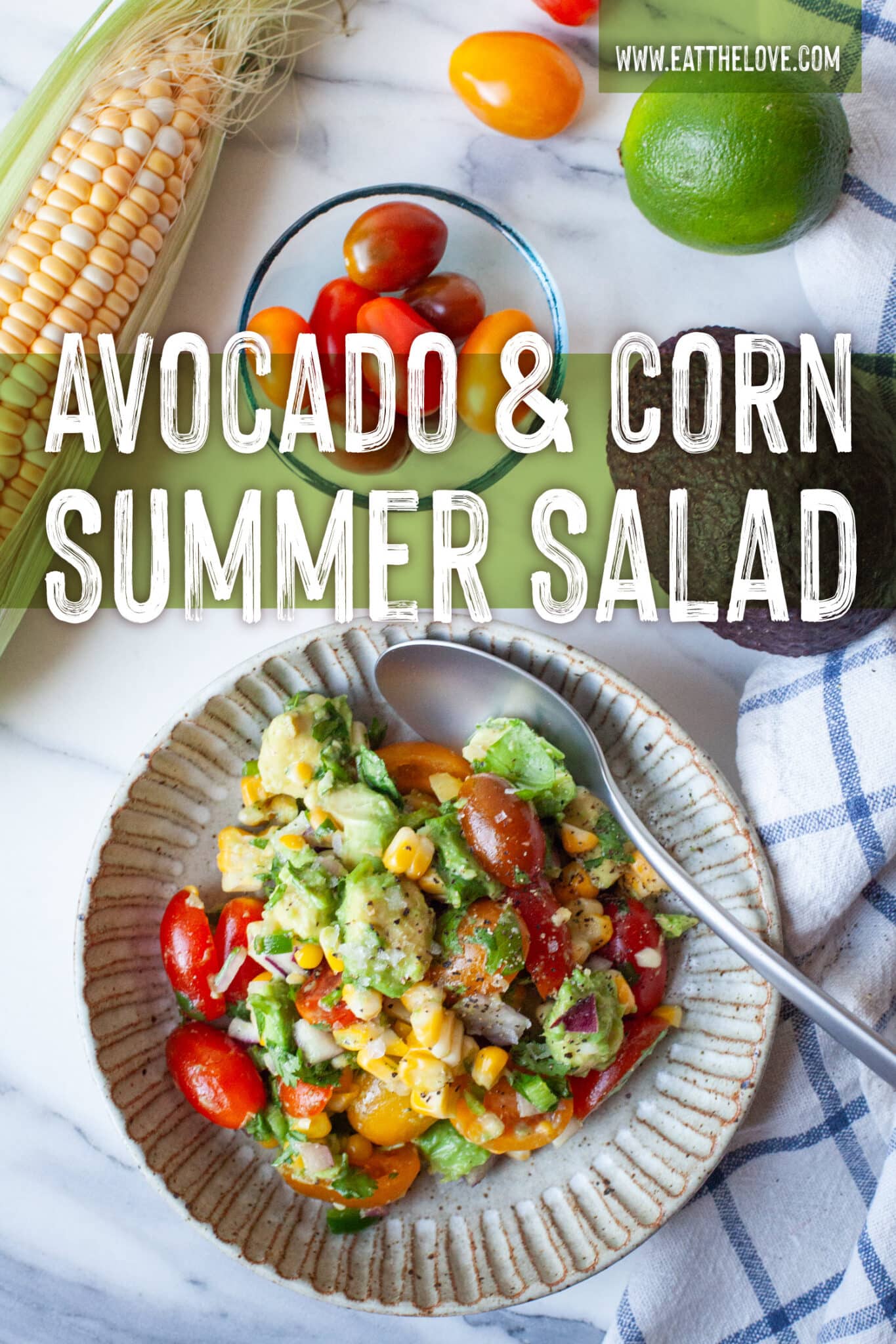 A bowl of avocado and corn salad, with an ear of corn, grape tomatoes, and a lime next to the bowl. The type on the image says Avocado and Corn Summer Salad.