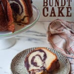 A slice of marble bundt cake on a plate, with the remaining cake behind it on a cake stand. The type on the image says "Chocolate and Vanilla Marble Bundt Cake".