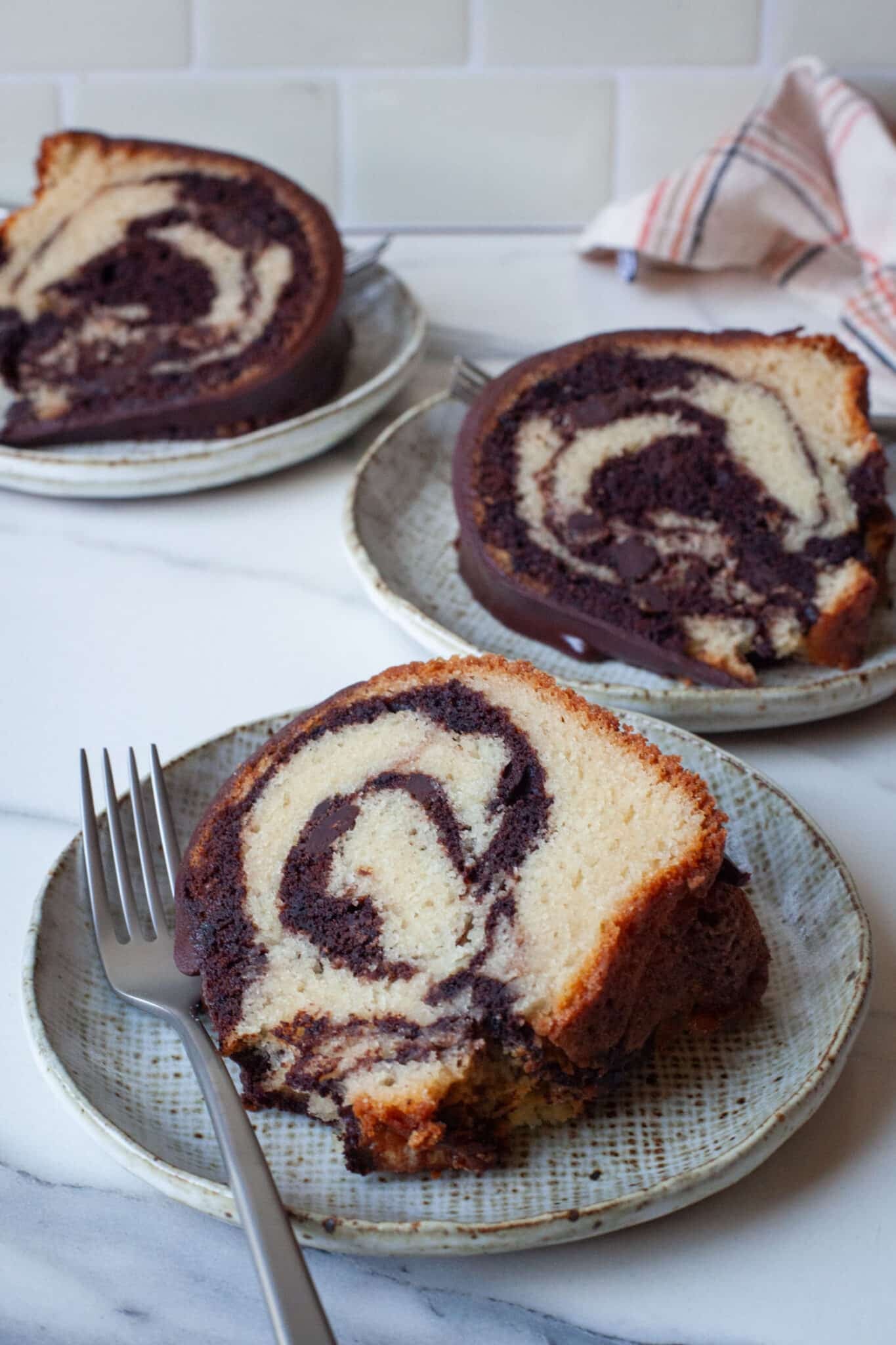 Slices of marble bundt cake on individual plates.