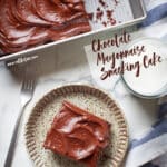 A slice of chocolate mayonnaise cake on a plate, with the remaining cake in a pan next to it.