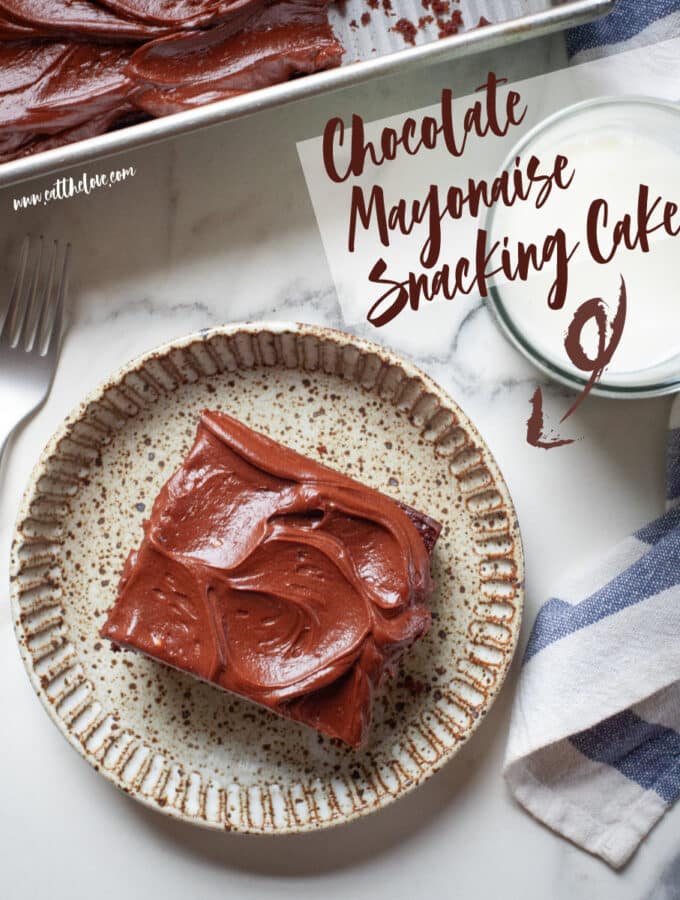 A slice of chocolate mayonnaise cake on a plate, with the remaining cake in a pan next to it.
